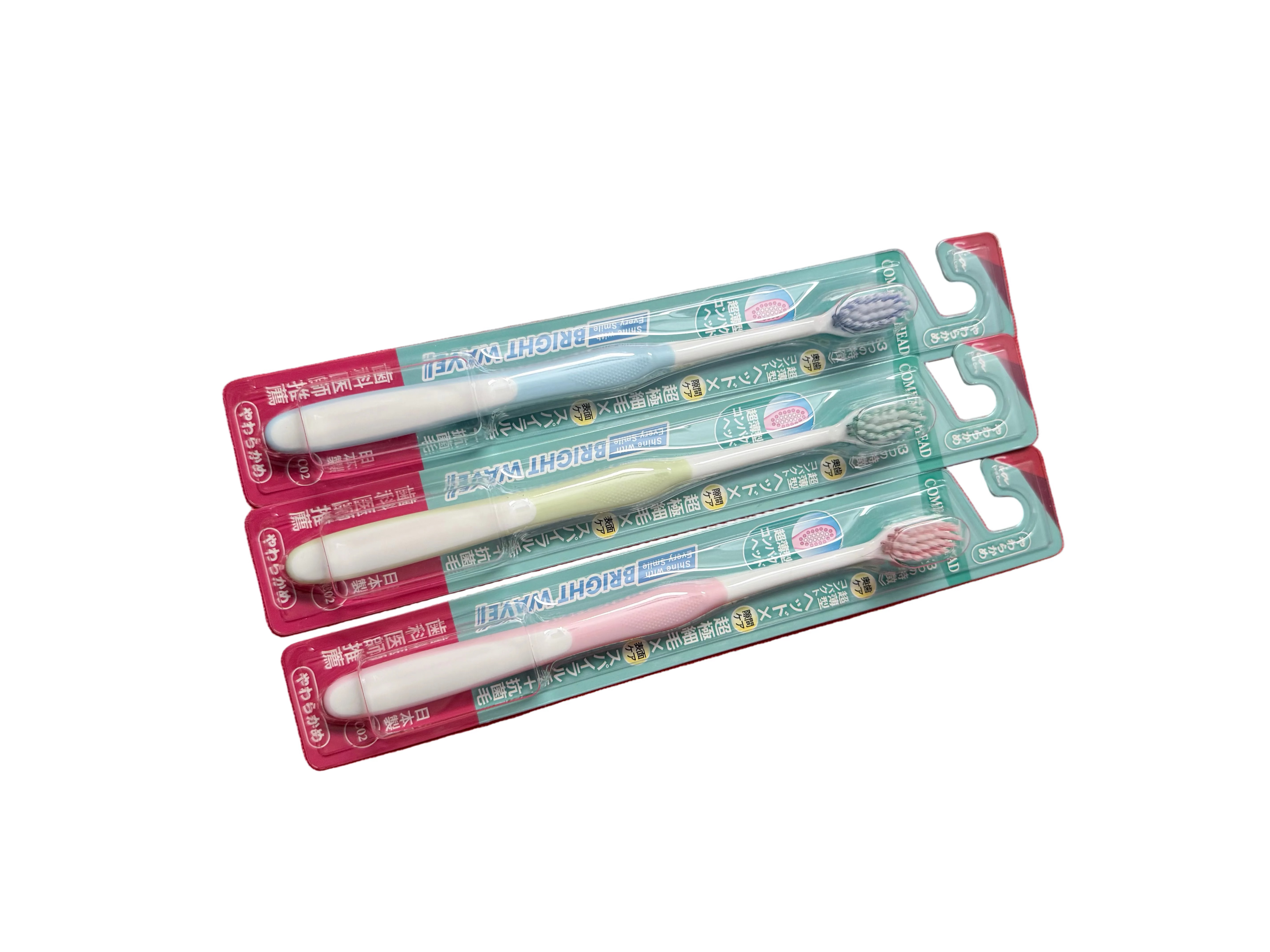 Four toothbrushes in their packaging on a white surface