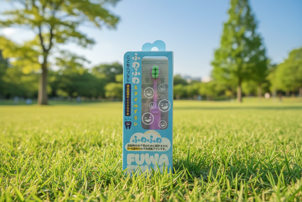Packaged children's toothbrush with pink handle and green bristles on a wooden surface