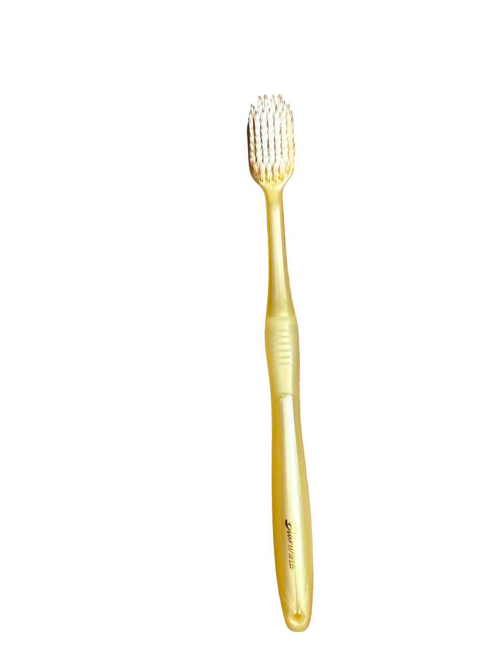 Gold toothbrush on a white surface